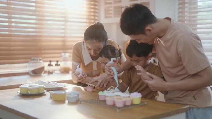 快乐的亚洲家庭在家里一起烘焙，做美味的糕点。