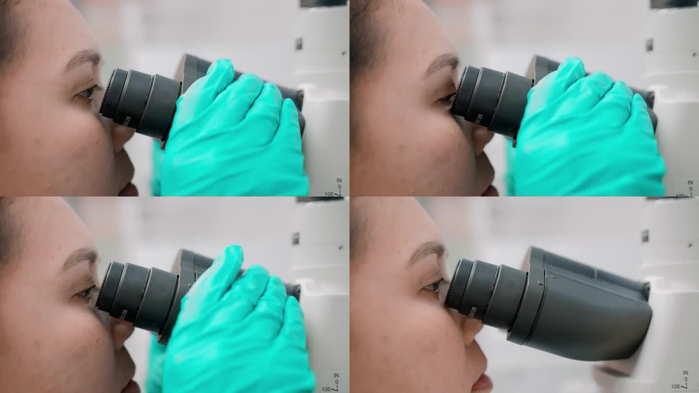 一位女科学家在光学显微镜上调整眼睛的焦距，以便观察微小的细节。