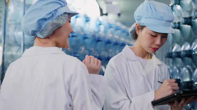 勤奋而自信的女质量管理经理正在检查装瓶厂仓库里的空加仑。以精确和专业的方式领导检验过程。团队精神和团