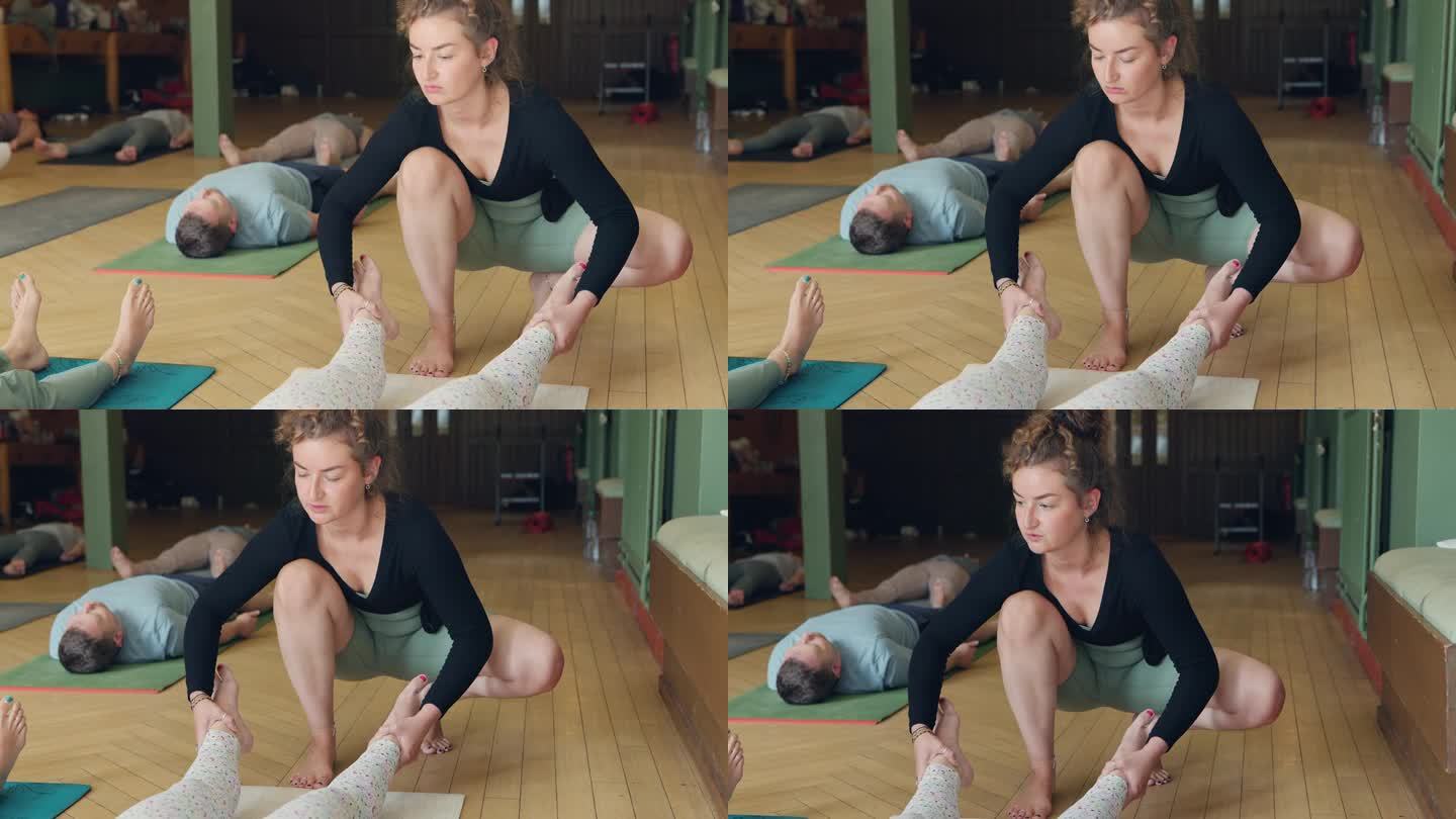 锻炼，脚和一个女瑜伽老师在课堂上与一群人的健康或保健。健身，训练和禅宗锻炼与一个年轻的瑜伽教练在课上