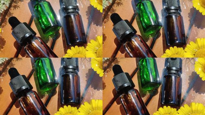 棕色和绿色的瓶子里装着鲜花里的精油。天然护肤化妆品。注重健康和美丽。
