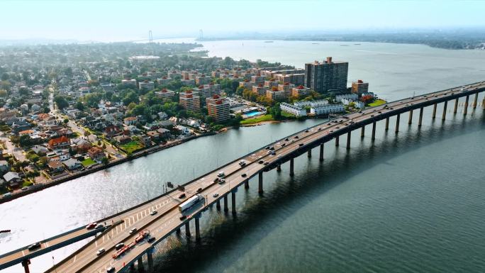 纽约皇后区海湾露台阳光明媚的城市景观。无人机降落在东河上的Throgs Neck桥上的画面。