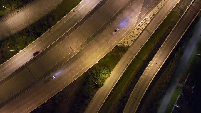 上图是佛罗里达州坦帕市宽阔的高速公路十字路口，夜间车辆疾速行驶。美国交通基础设施概念