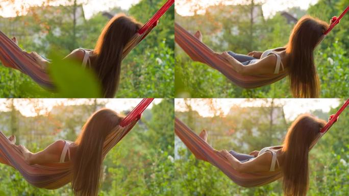 Woman enjoying summer, swaying in a hammock at sun
