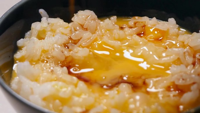 一个把酱油涂在生鸡蛋和米饭上的视频。从左到右。