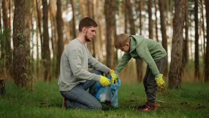 父子俩在森林里捡塑料垃圾，保护环境，拯救生态，拯救自然