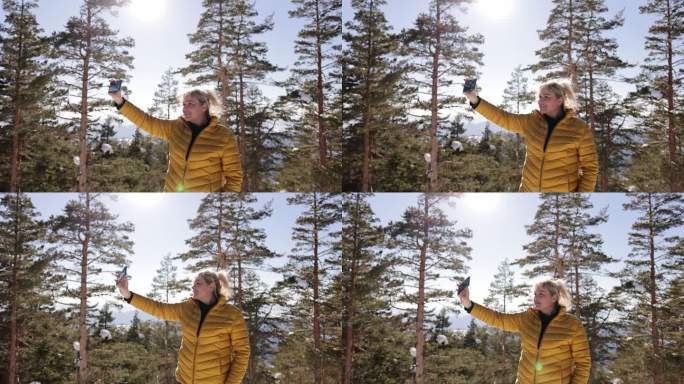 寒假期间，一名白人女子在森林里用手机自拍