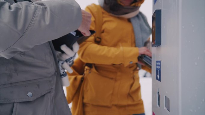 一名妇女用信用卡在自动售货机前进行非接触式付款