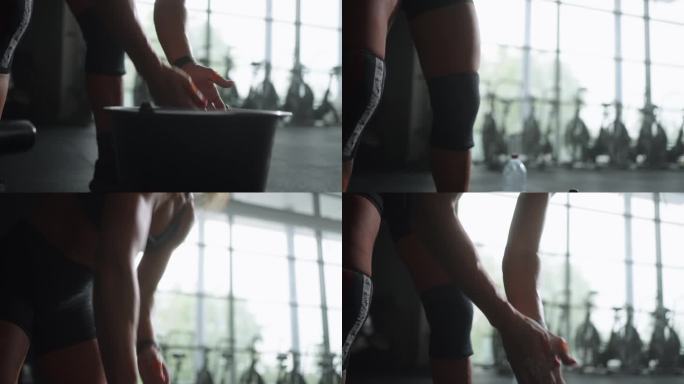 在硬举训练前，女运动员在手掌上涂抹镁粉，独自在健身房训练，特写