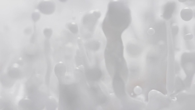 牛奶溅在慢动作和宏观-抽象白色大力弹跳流体使滴和飞溅