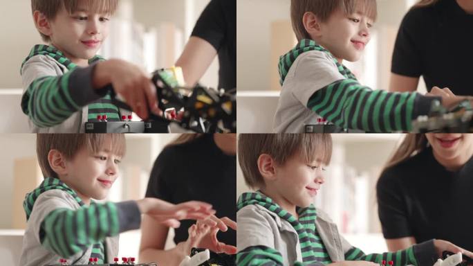 聪明的孩子男孩玩机器人玩具使用电线遥控玩干机器人玩具在家里。提高工程技能和想象力的活动。教育的创新和