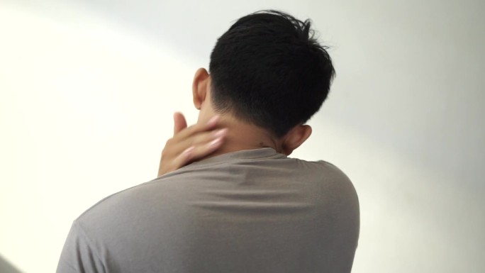 一个亚洲年轻人因为皮肤发痒而抓挠脖子