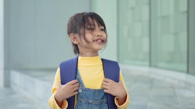 一个小女孩高兴地背着书包，去上学。