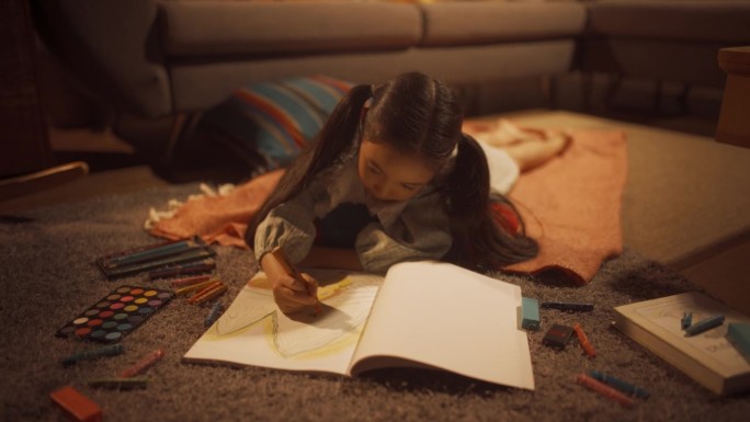 可爱小女孩躺在客厅地板上画的晚照。韩国天才儿童的创作，上色，准备成为著名的艺术家。电影缩放多莉