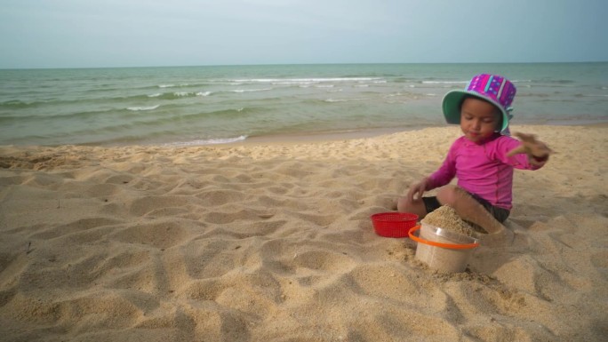 快乐的海滩游戏:无忧无虑的孩子在阳光明媚的海岸线上堆沙堡