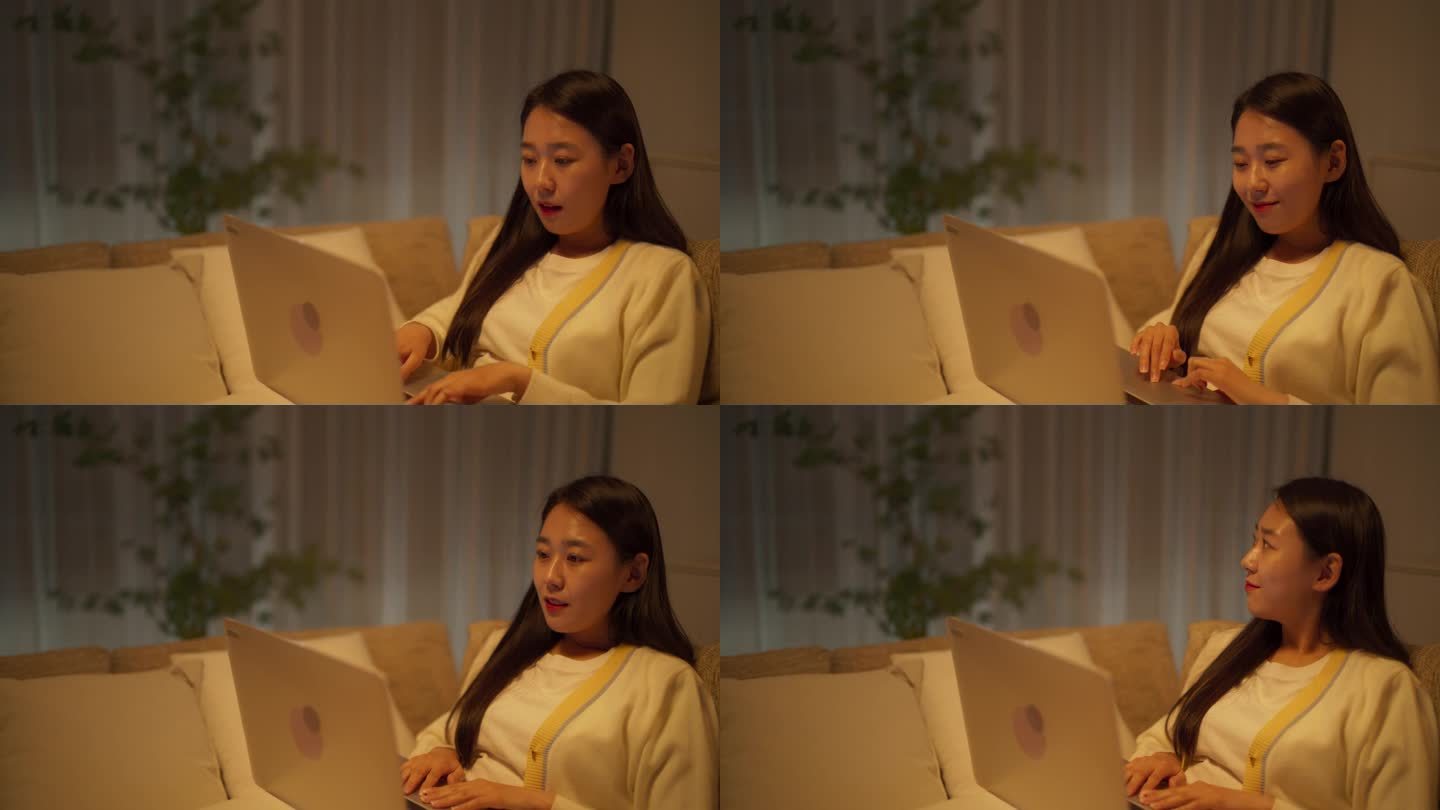 受启发的韩国自由撰稿人在舒适的沙发上放松工作。深夜，在极简主义的客厅里，一位女士在笔记本电脑上写了一