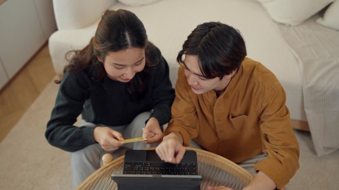 情侣们一边在家放松，一边在平板电脑上网购。
