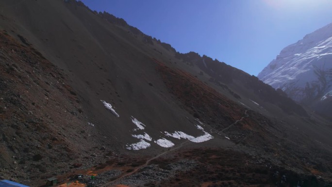 航拍照片显示徒步旅行者在喜马拉雅山脉山顶的建筑物。在提里科大本营徒步旅行。住宿宾馆建筑，旅游理念。