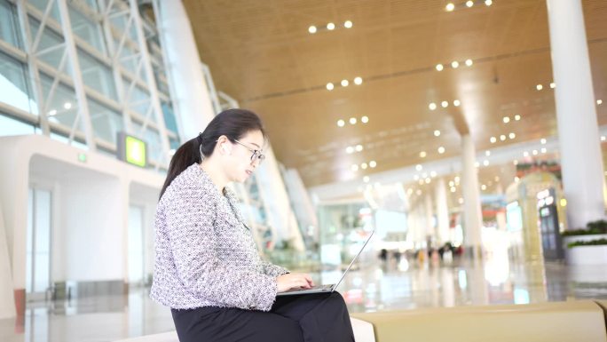 亚洲女商人在机场售票大厅使用电脑