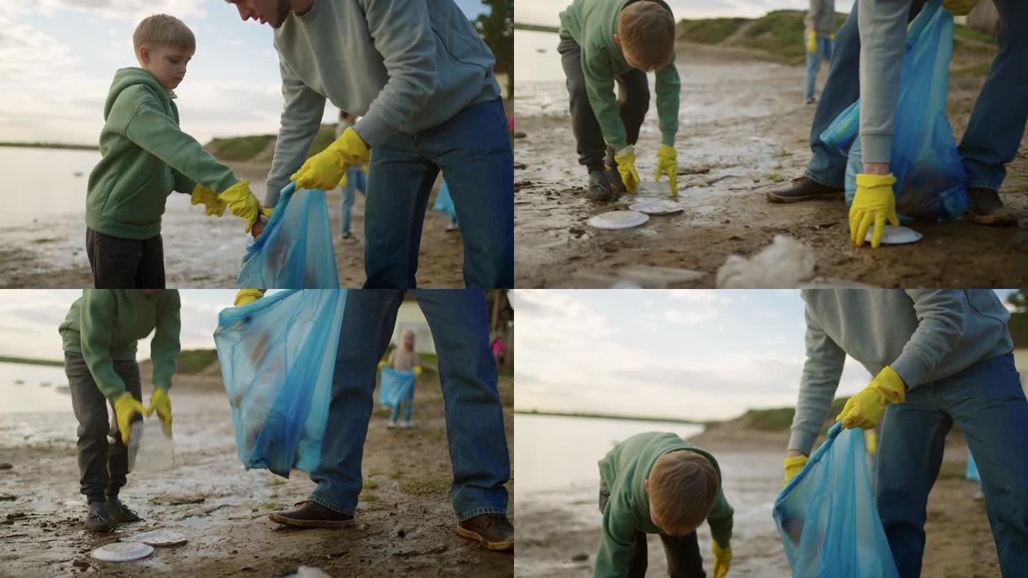 十几岁的男孩和他的父亲在河边捡垃圾，生态和环境保护