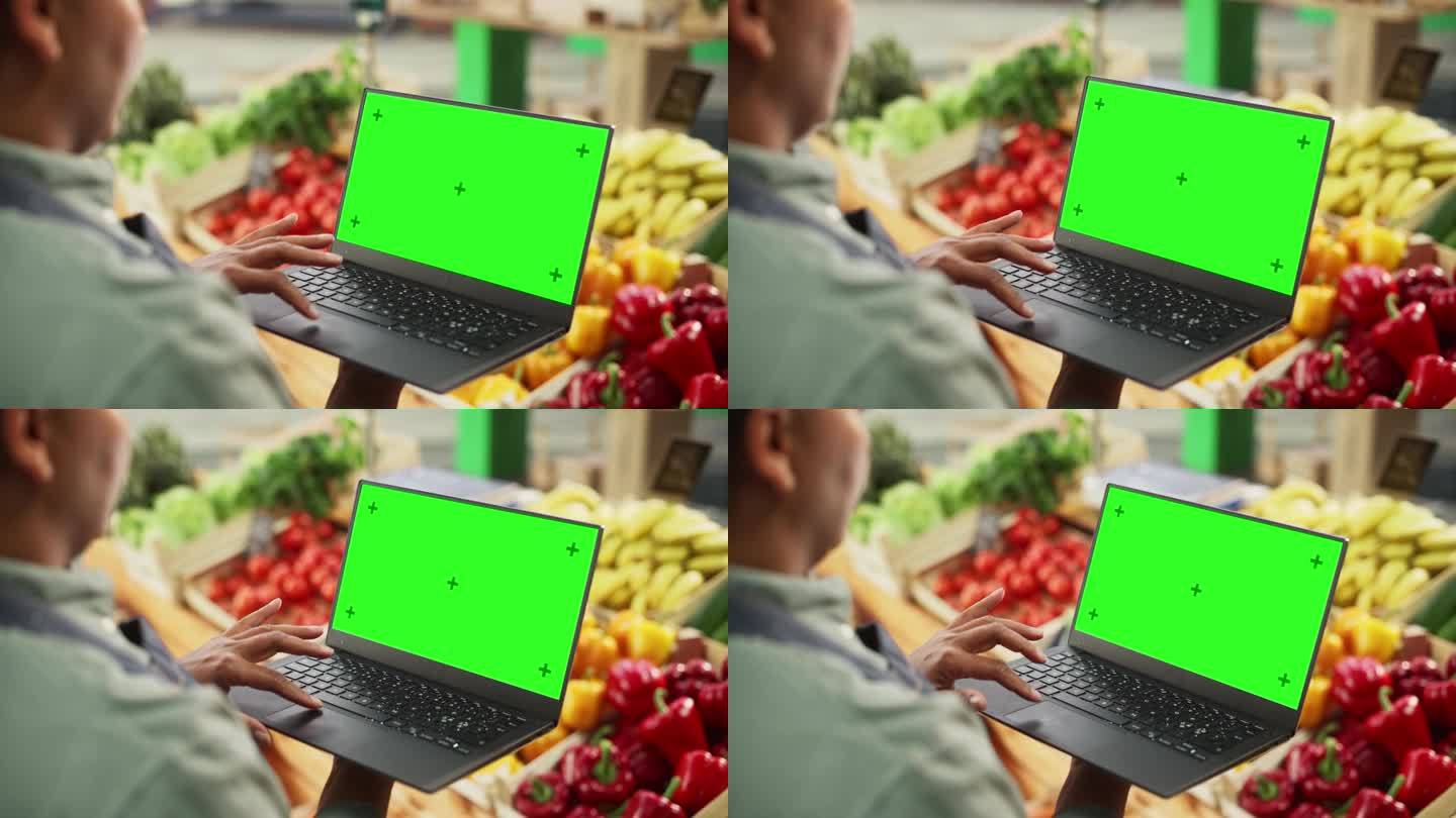 一位匿名的非洲农民在一台有绿屏模拟显示的电脑上工作。一个街头小贩用笔记本电脑与可持续水果和蔬菜供应商