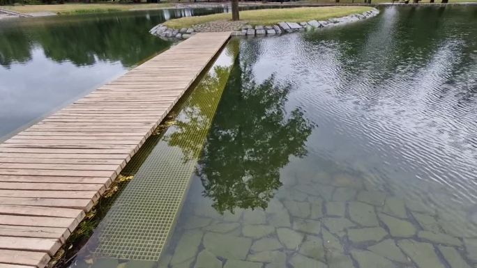 公园没有栏杆。在它旁边的水里是一个淹没在水面下的安全网。这样可以拓宽桥梁，减少坠向纵深的可能性