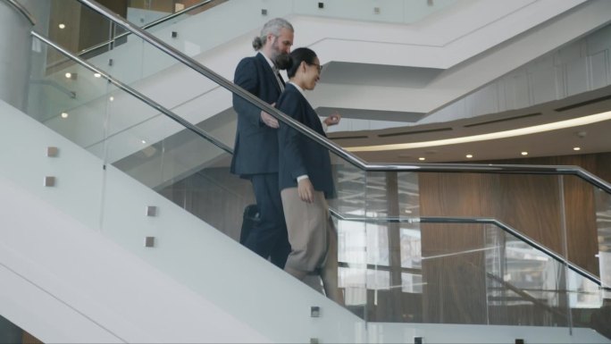 一个商人和一个女人走下现代豪华酒店的楼梯