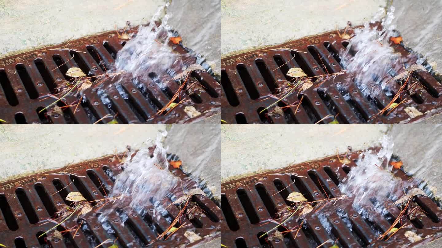 大雨后的水流通过雨水收集器的金属格栅流入下水道。城市的雨水下水道系统