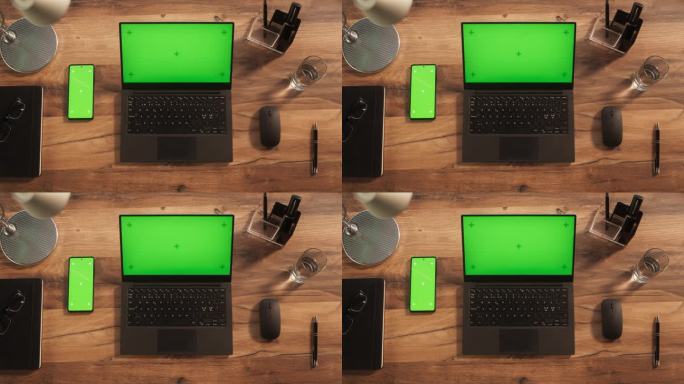 一台笔记本电脑的俯视图与模拟绿屏站在办公桌旁边的智能手机与模板Chromakey显示与运动跟踪占位符
