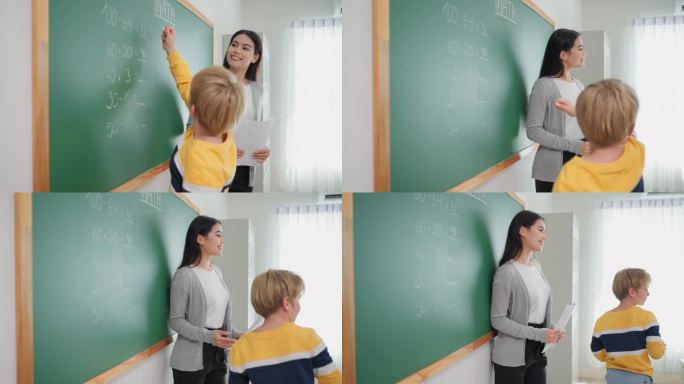 一个小学男孩走出教室去做数学题，女老师站在他旁边