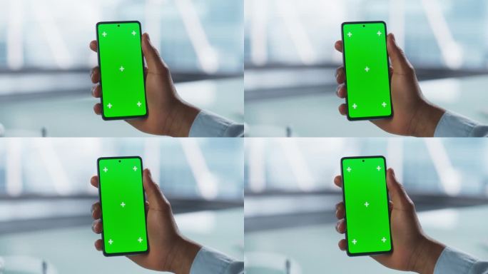 匿名商人拿着绿屏模拟显示屏的智能手机，在专业的办公环境中进行视频通话。虚拟会议、现代技术和互联互通概