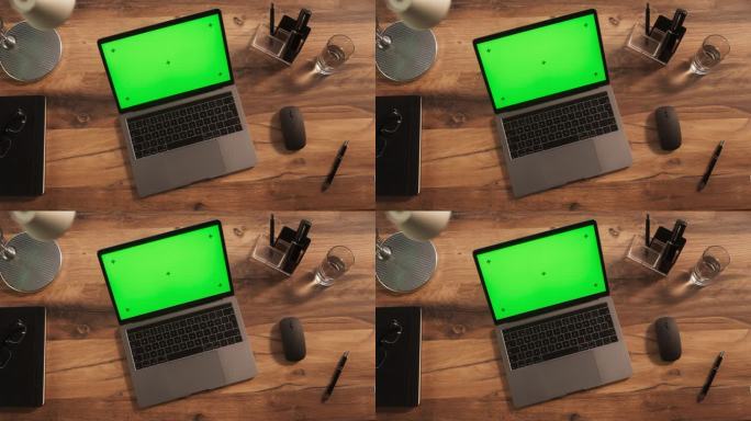 笔记本电脑的俯视图，模拟绿屏Chromakey显示器与运动跟踪器站在木制办公桌旁边的无线鼠标，黑色钢