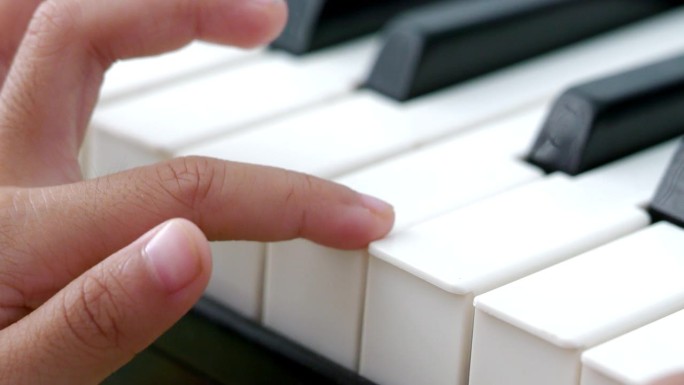 女孩用手指弹钢琴。