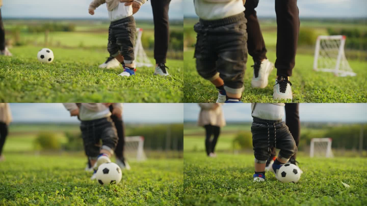 父亲带着小男孩在绿地上踢足球
