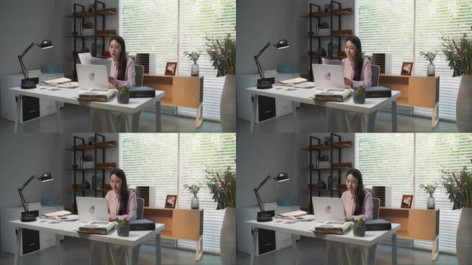 才华横溢的韩国建筑师在时尚的现代工作空间中使用笔记本电脑。年轻的创意女性将道路网络概念转化为鼓舞人心