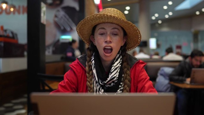 中年成年女性在机场的咖啡店进行视频通话