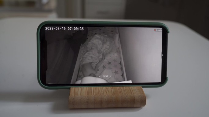 手机上的无线安全摄像头监控着熟睡的孩子