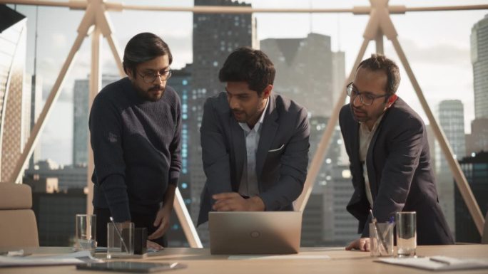 印度青年企业家与两个南亚商业伙伴会面。决心达成协议的商人，借助笔记本电脑讨论机会