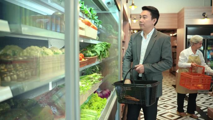 有魅力的商人站在超市的货架前挑选蔬菜和日用品。残疾超市。