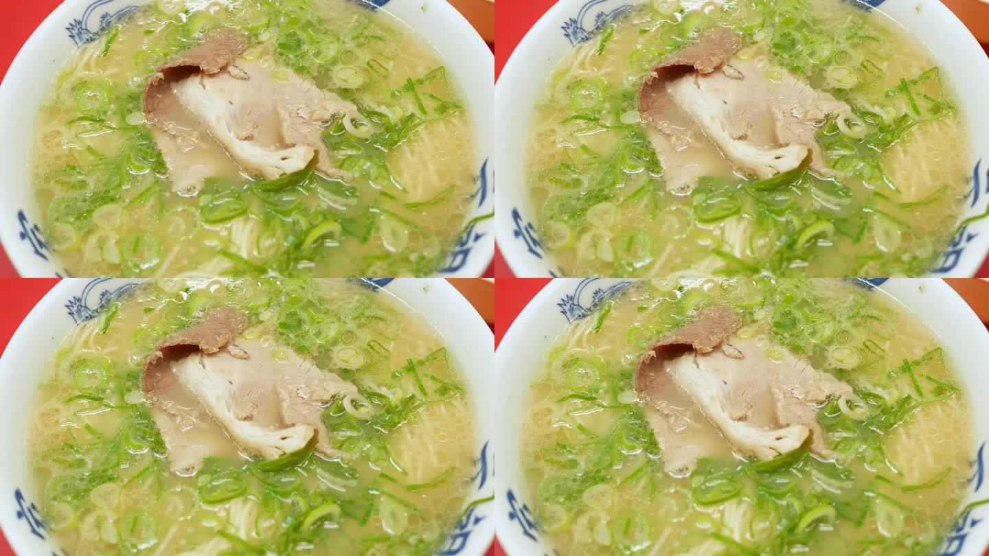 豚骨酱拉面用煮熟的猪肉片和洋葱片。日本国菜拉面碗热汤