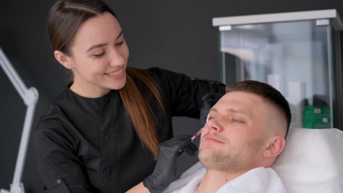 一位年轻的欧洲男子接受美容师注射肉毒杆菌