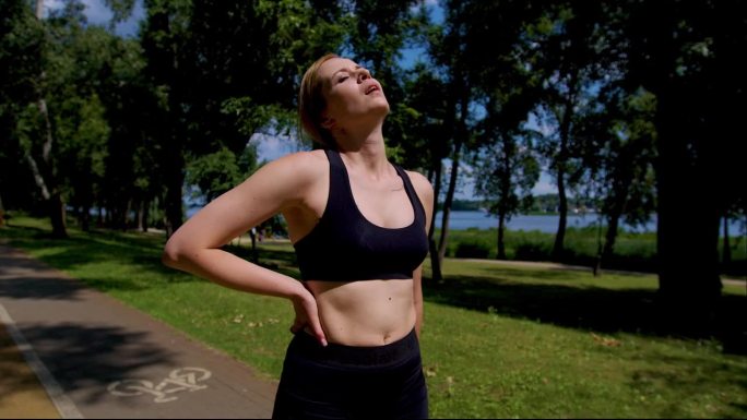疲惫的运动健身女慢跑者在激烈的户外跑步后喘口气