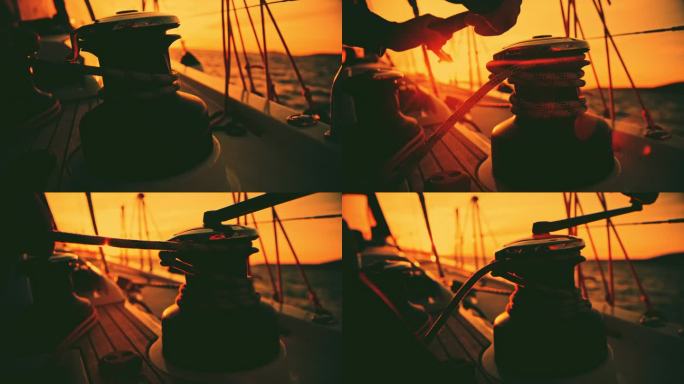 日落时分，男子在游艇上的绞车上系绳