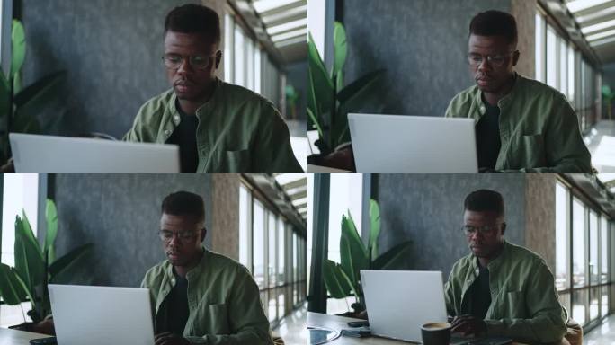 一位戴着黑色眼镜的作家在电脑前热情地工作，专注于创作一篇新文章。