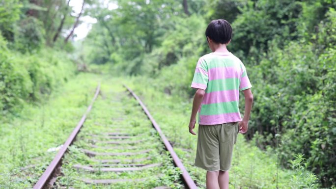 男孩走在铁轨上小男孩废弃铁山沟大山树林自