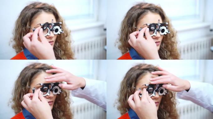 在眼科诊所，验光师在试验框架内更换镜片以检查年轻女性患者的视力