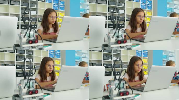 书呆子白人女孩在笔记本电脑上为机器人编写程序