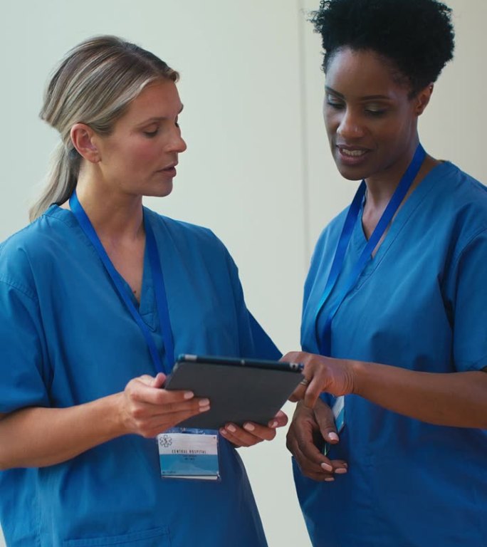 两个成熟的女医生在医院用数字平板电脑会面的垂直视频