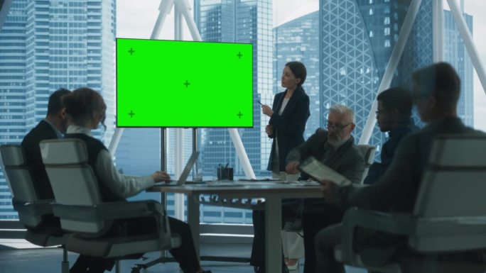 办公室会议室演示:美丽的女商人讲话，使用绿屏Chromakey电视。企业家在会见不同投资者时展示电子