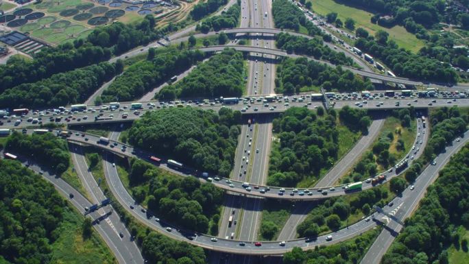 鸟瞰图上的交通在一个主要的高速公路交汇处，满是汽车和卡车。用红色武器8K拍摄。